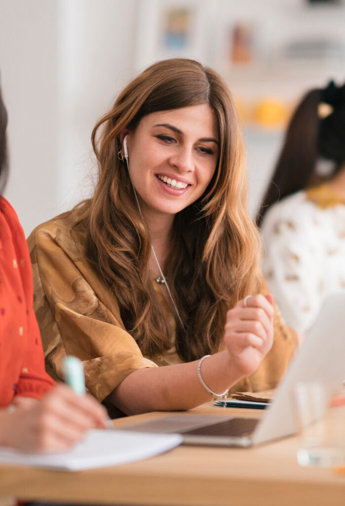 Woman smiling with headphones and a laptop