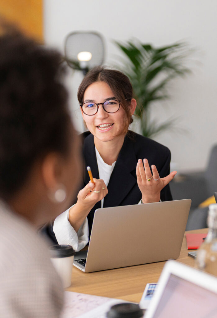 Woman with glasses talking at conference table