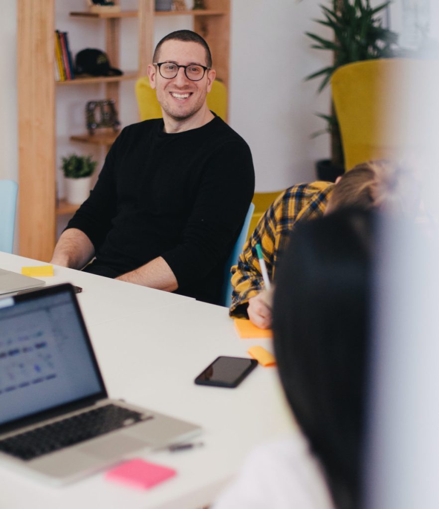 Three people in a desk writing stuff on post-its and laughing.