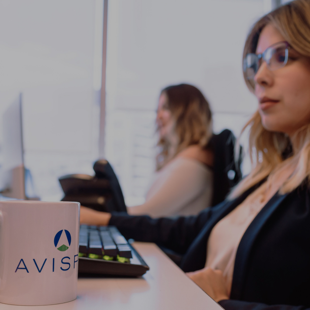 Two women sitting at their desks, working on their computers.