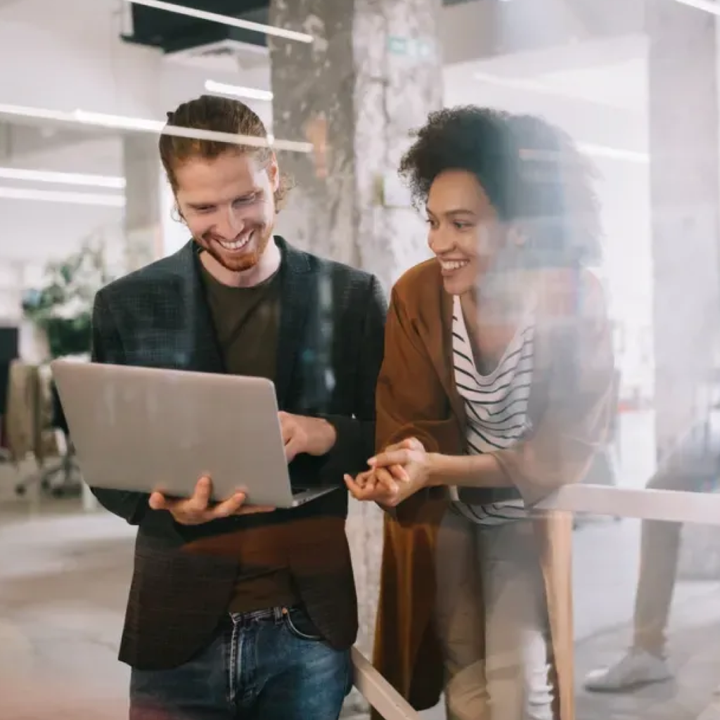 Smiling Man and Woman Looking at Notebook Together