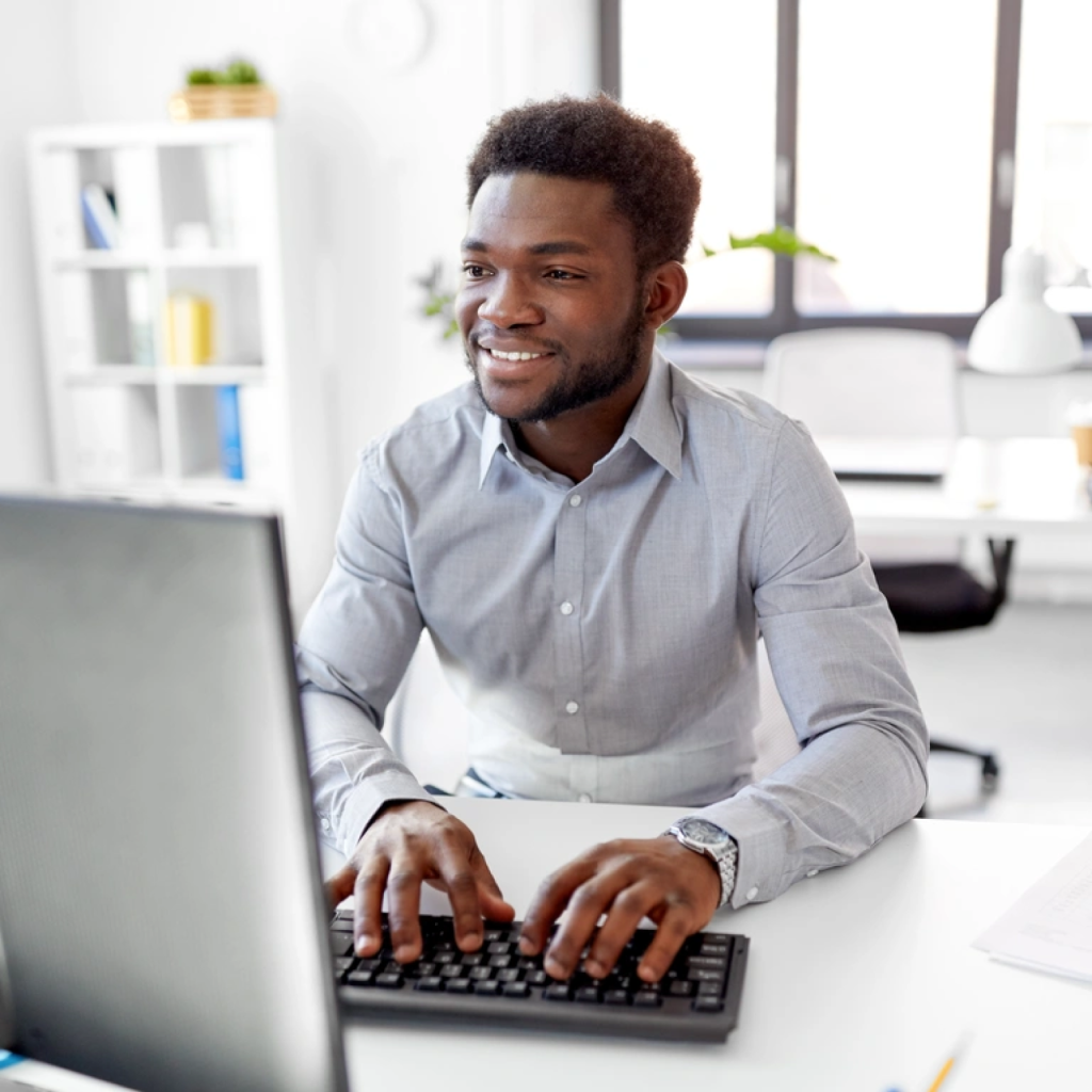 Smiling Man Typing on a Computer